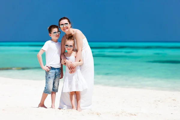 Мать и дети на тропическом пляже — стоковое фото