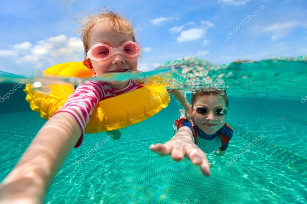 Kids having fun swimming on summer vacation Stock Photo by ©shalamov