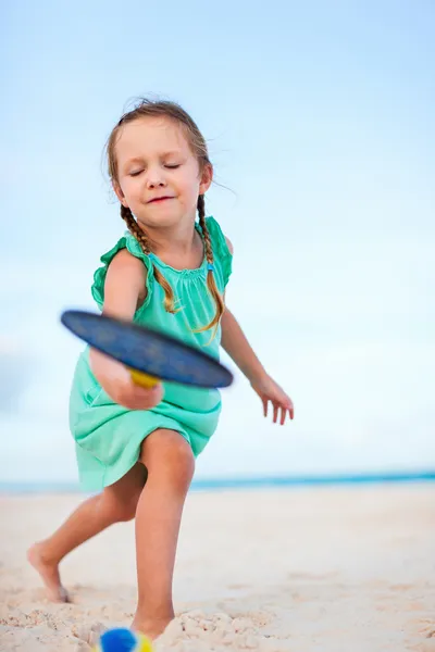 Mała dziewczynka gra tenis plażowy — Zdjęcie stockowe