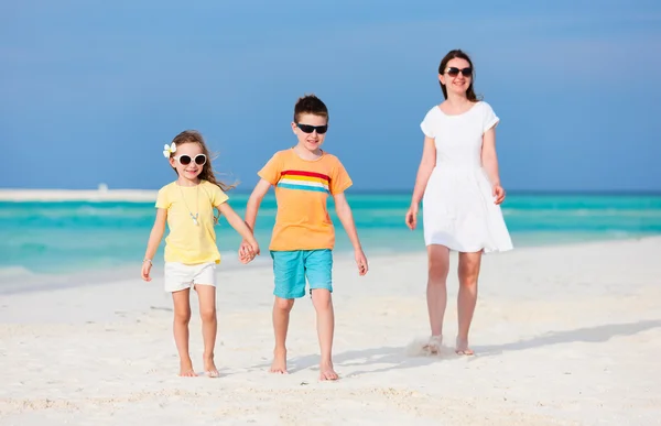 Moeder en kinderen op een tropisch strand — Stockfoto