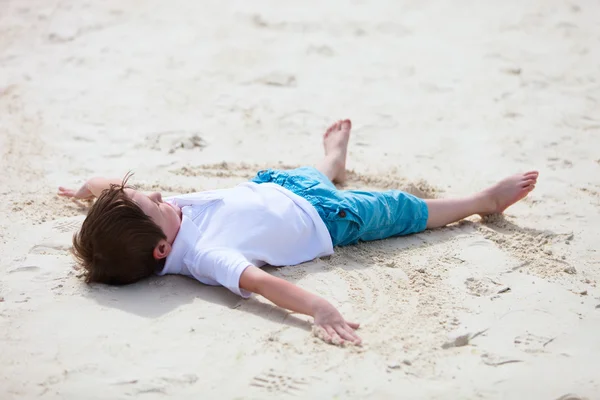 Liten pojke spelar på stranden — Stockfoto