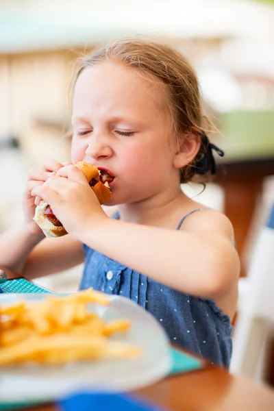 Dziewczynka jedzenie hot dog — Zdjęcie stockowe