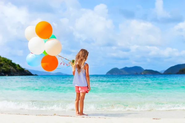 Vista posteriore della bambina con palloncini in spiaggia — Foto Stock