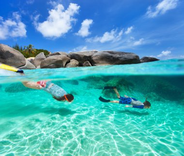 Family snorkeling in tropical water clipart