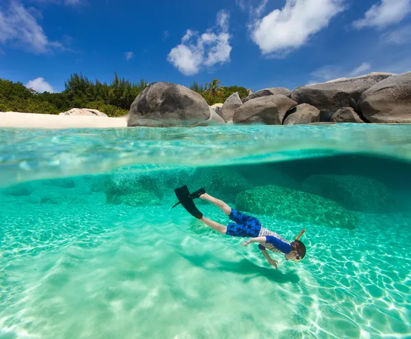 Liten pojke snorkling i tropiska vatten — Stockfoto