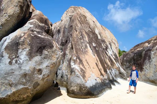 Little boy among huge granite boulders — Stock Photo, Image