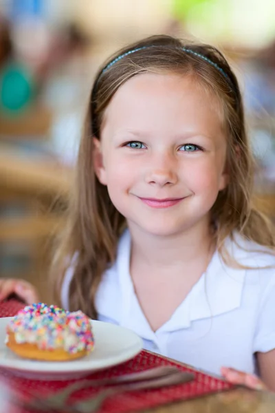 Little girl eating donut — Stock Photo, Image