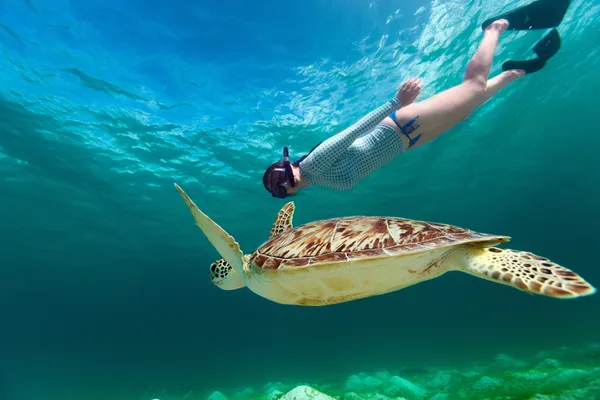 Mujer joven haciendo snorkel con tortuga marina — Foto de Stock