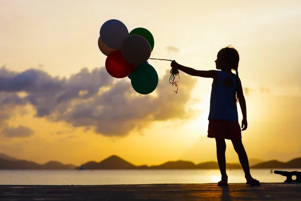 Boldog lány léggömbökkel a naplemente — Stock Fotó
