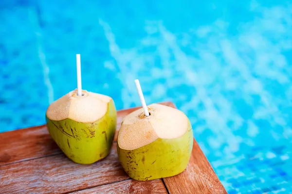 ターコイズブルーの水の近くの2つの新鮮な緑のココナッツは トロピカルリゾートでドリンクを歓迎します — ストック写真