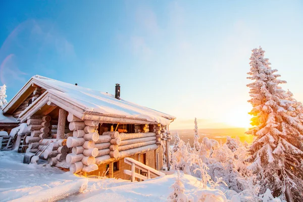 芬兰拉普兰美丽的冬季风景 有木制小屋和白雪覆盖着落日的树木 — 图库照片