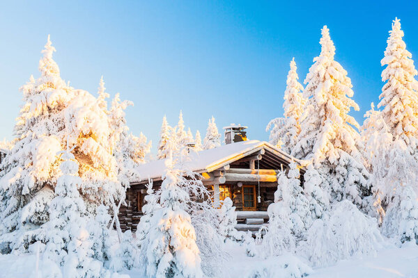 Beautiful winter landscape with wooden hut and snow covered trees in Lapland Finland