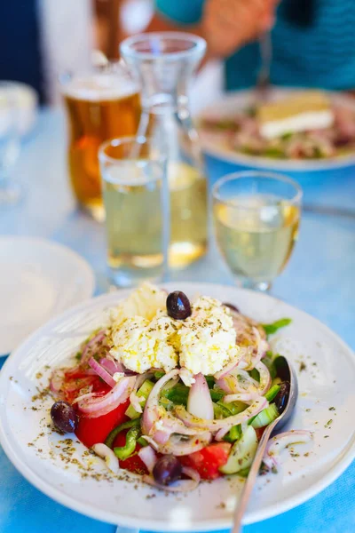 美味的希腊沙拉 新鲜蔬菜和希腊山羊乳酪 与白葡萄酒一起在餐馆吃午饭 — 图库照片