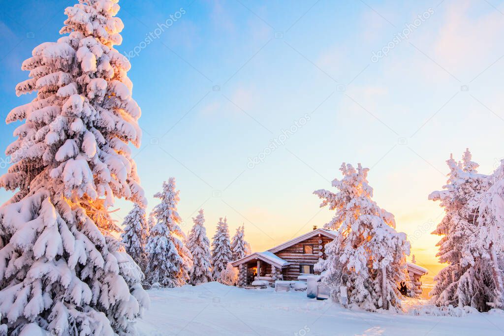 Beautiful winter landscape with wooden hut and snow covered trees in Lapland Finland