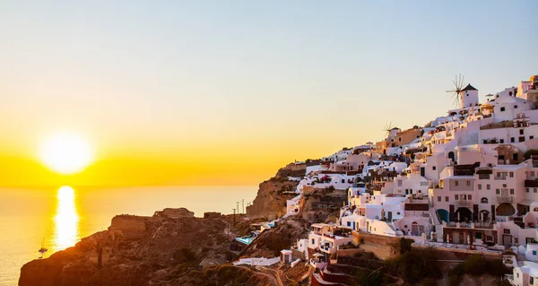 希腊圣托里尼岛上有着传统白色建筑和蓝色圆顶教堂的欧亚村令人叹为观止的日落景象 — 图库照片
