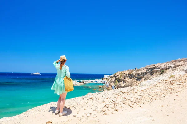 ギリシャのミロス島の地中海とマンドラキアの伝統的な漁村の景色を楽しむ若い女性のバックビュー — ストック写真