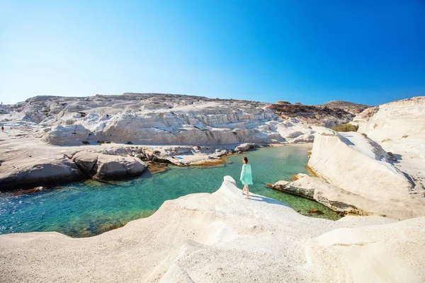 ギリシャのミロス島のサラキニコビーチの風景のように月を歩く若い女性のバックビュー — ストック写真