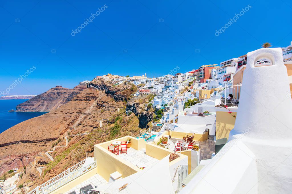 Breathtaking view of Thera village with traditional white architecture and blue-domed churches on Santorini island in Greece
