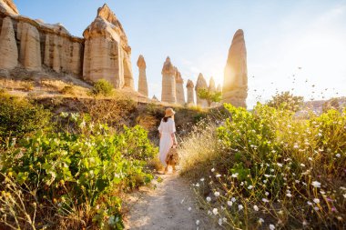 Young woman walking in Love valley in Cappadocia Turkey among rock formations and fairy chimneys