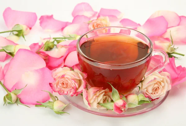Thee en bloemblaadjes van roze rozen — Stockfoto