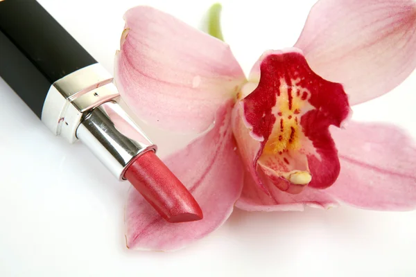 Cosmetici decorativi e orchidea rosa — Foto Stock