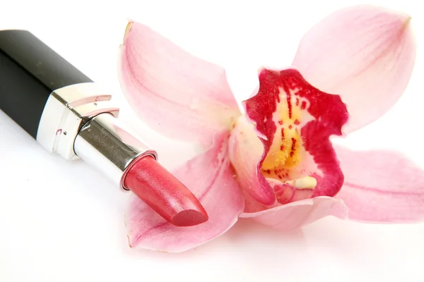 Cosmetici decorativi e orchidea rosa — Foto Stock