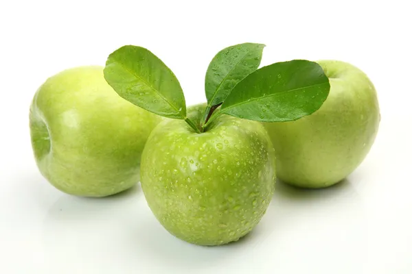 Frische grüne Äpfel mit Blättern — Stockfoto