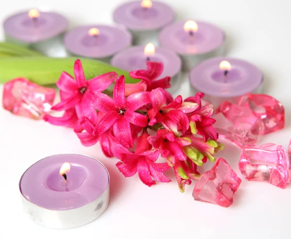 Flor rosa e velas acesas — Fotografia de Stock