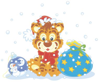 Kırmızı beyaz Noel Baba şapkalı şirin bir kaplan güzel bir hediye çantası ve Noel oyuncak topu ile karda oturuyor. Beyaz arka planda izole edilmiş vektör karikatür çizimi.