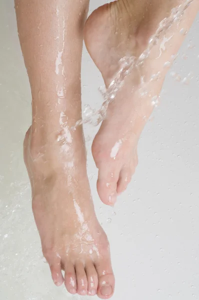 Woman 's foots and drop' s of water — стоковое фото