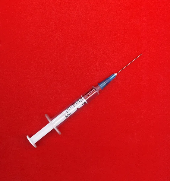 Syringe on red — Stock Photo, Image
