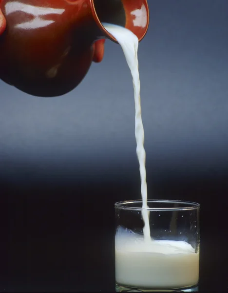 Gießen Sie ein Glas Milch — Stockfoto