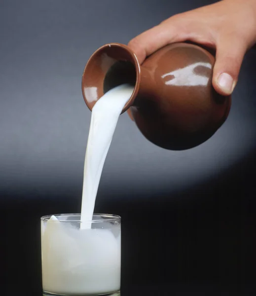 Giet een glas melk — Stockfoto