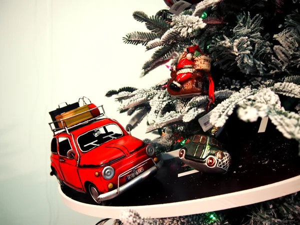Paseos en coche de juguete en el camino alrededor del árbol de Navidad Imágenes de stock libres de derechos