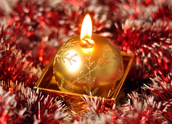 Goldene Weihnachtskerze auf rotem Hintergrund — Stockfoto