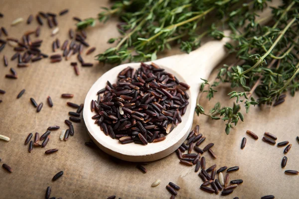 Red rice on wooden spoon — Stock Photo, Image