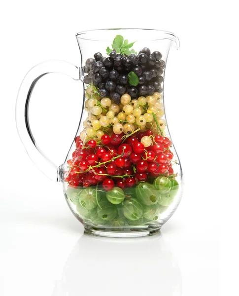 Glass jug with berries — Stock Photo, Image