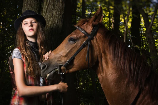 Cowgirl in hat with bay horse — Stock Photo, Image