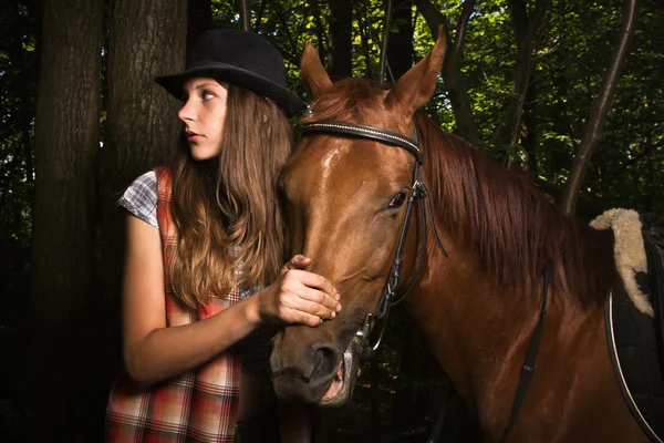 Cowgirl in hat with bay horse — Stock Photo, Image