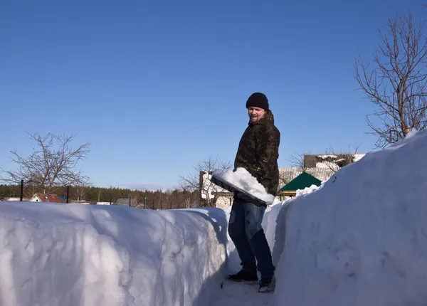 Man med en snöskyffel — Stockfoto