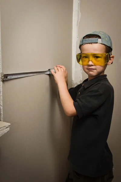 Boy in goggles with a tape measure — Stock Photo, Image