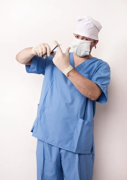 Surgeon in scrubs with scissor Royalty Free Stock Photos