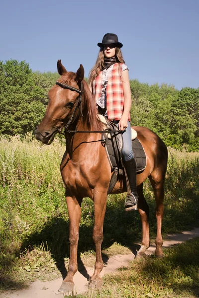 Cowgirl reitet auf einem braunen Pferd — Stockfoto