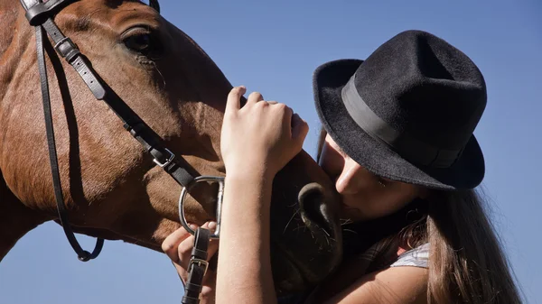 Cowgirl in cappello con cavallo baia — Foto Stock