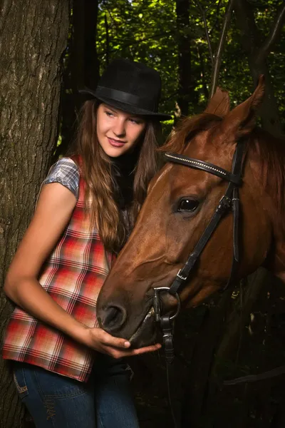 Cowgirl in hat with bay horse — Stock Photo, Image