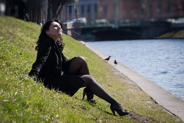 Vacker ung kvinna sitter vid floden kanalen — Stockfoto
