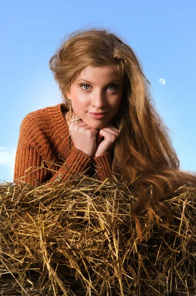 Pretty girl resting on straw bale — Stock Photo, Image