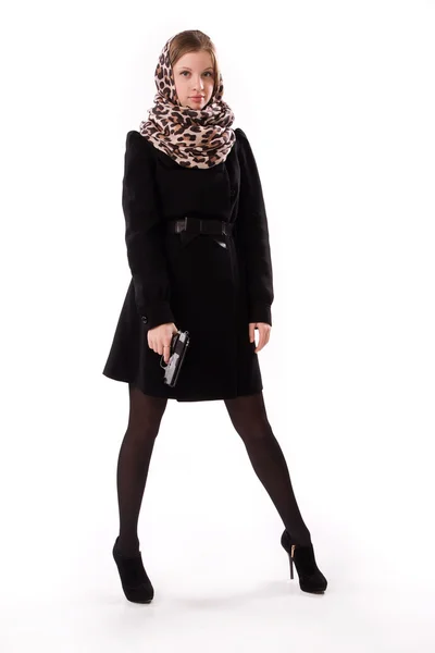 Spion meisje in een zwarte jas met pistool — Stockfoto