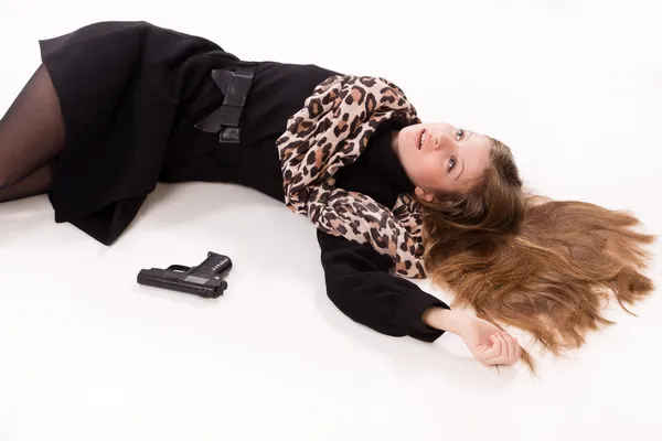 Chica espía con pistola tirada en el suelo —  Fotos de Stock