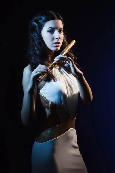 Sensuality brunette with a wooden flute — Stock Photo, Image